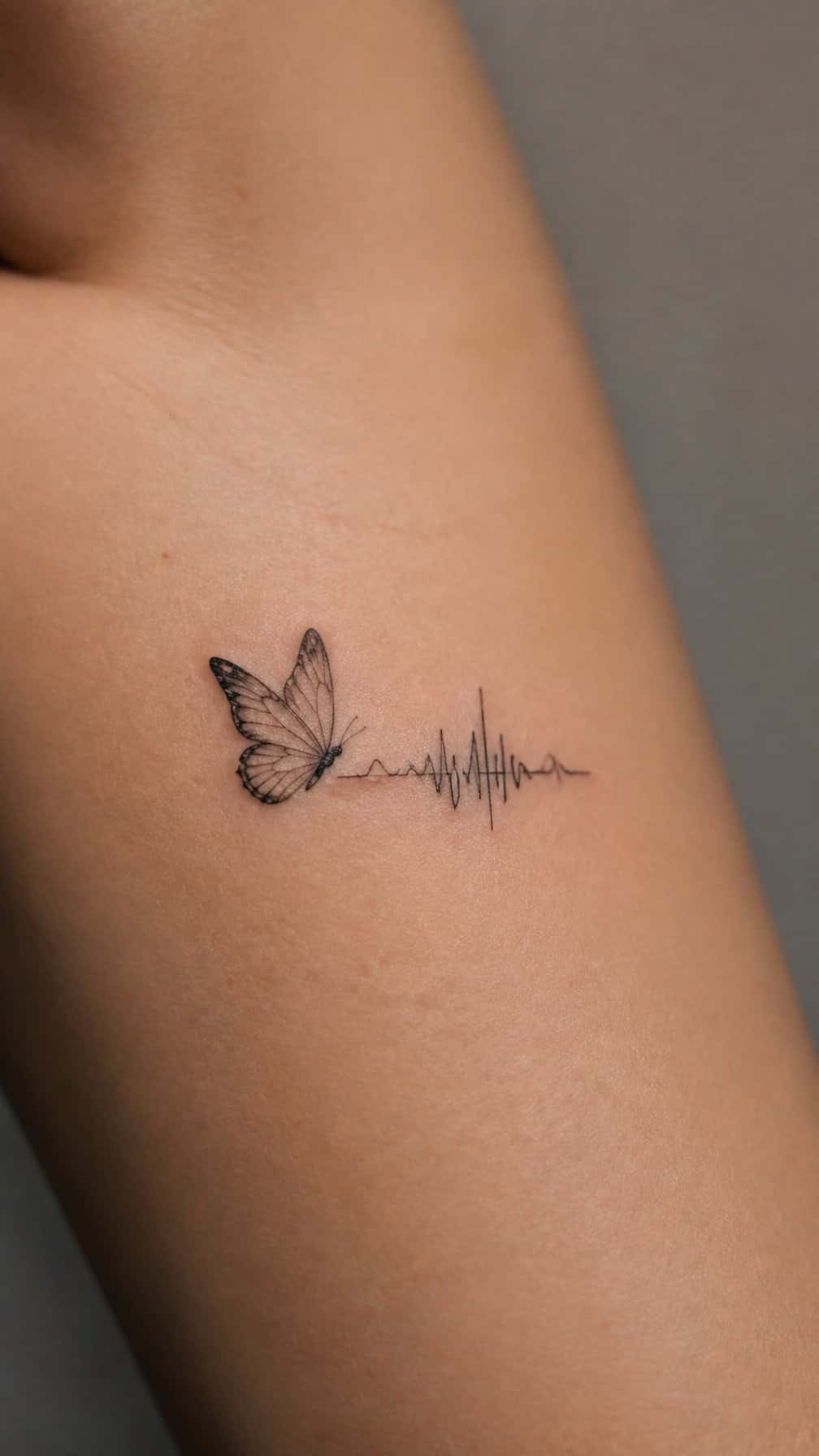 A small butterfly tattoo paired with an abstract soundwave design on skin.